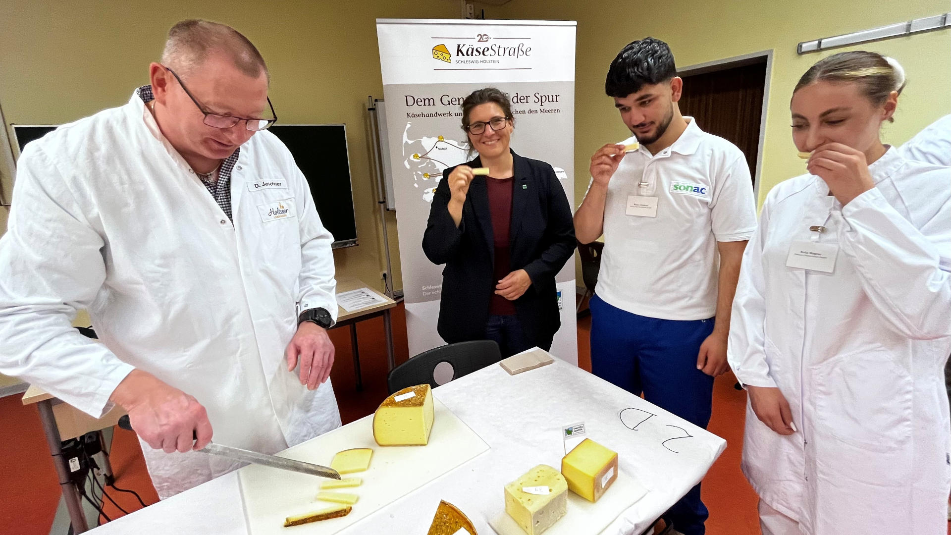 Zwei Frauen und Zwei Männer probieren zusammen Käse 