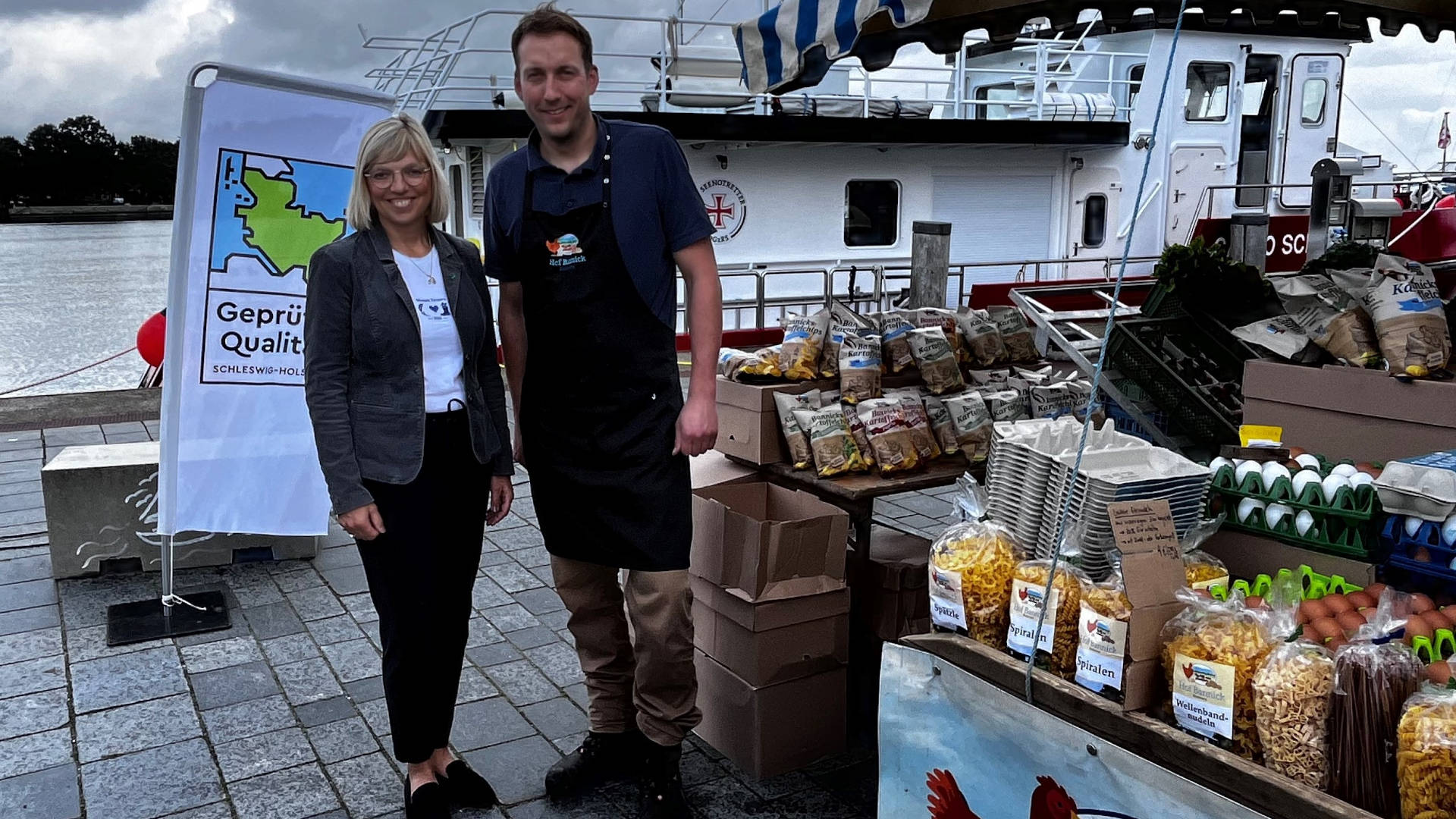 Ein Mann und eine Frau stehen zusammen für einer Beachflag