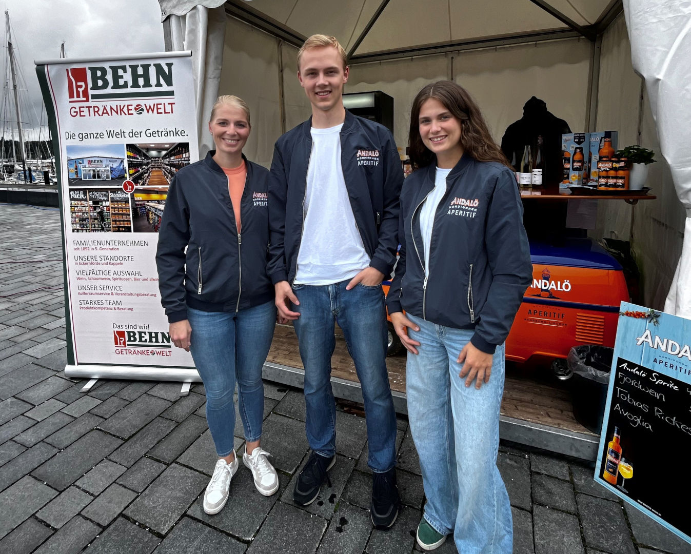 Zwei Frauen und ein Mann stehen zusammen