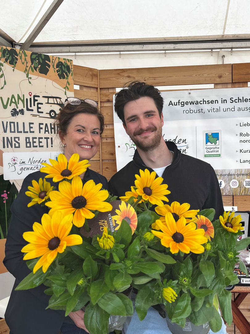 Eine Frau und ein Mann hinter einer Blume 