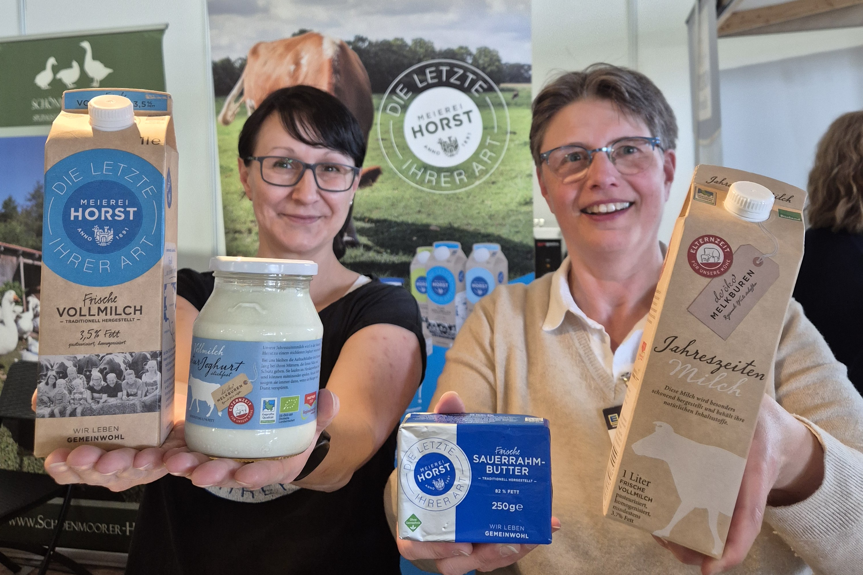 2 Menschen zeigen Produkte in die Kamera