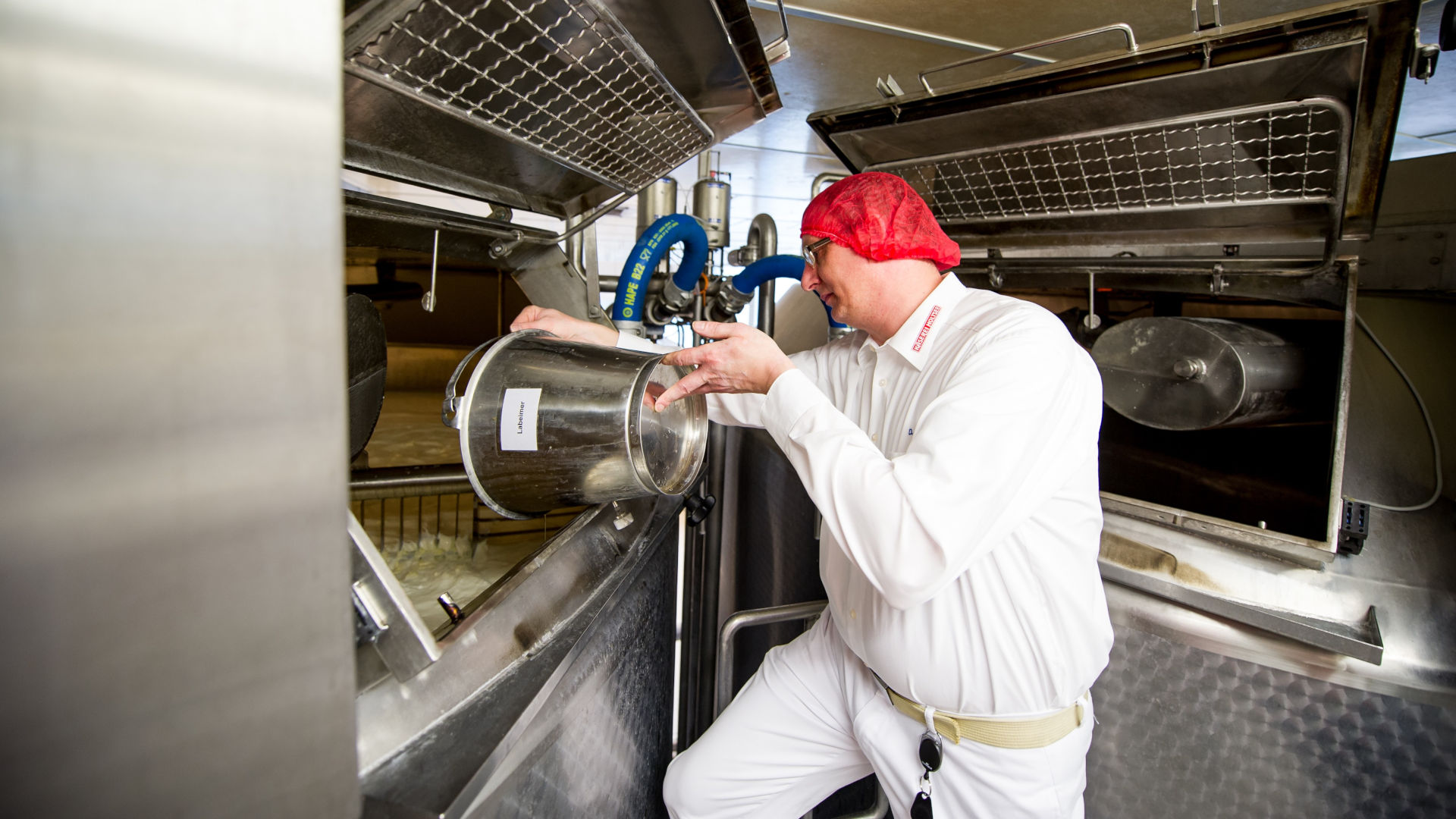 Ein Mann fügt Lab zur Milch dazu