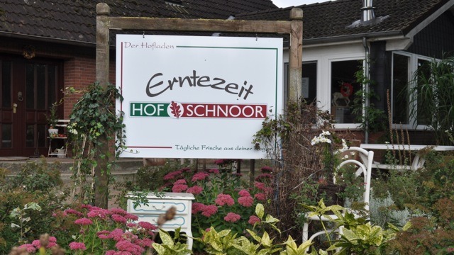 Hofschild, davor Blumen