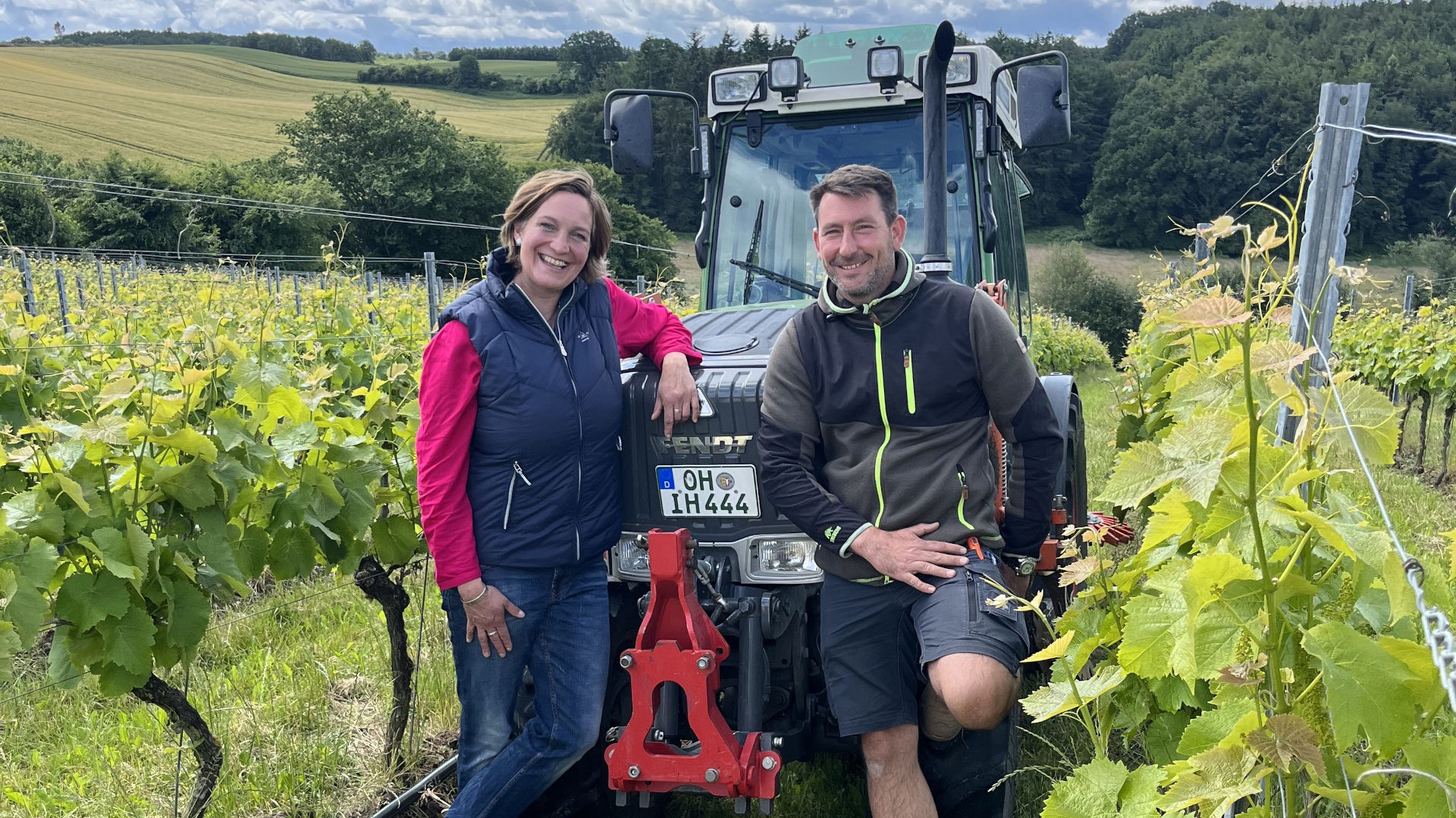 Eine Frau und ein Mann stehen vor einem Traktor