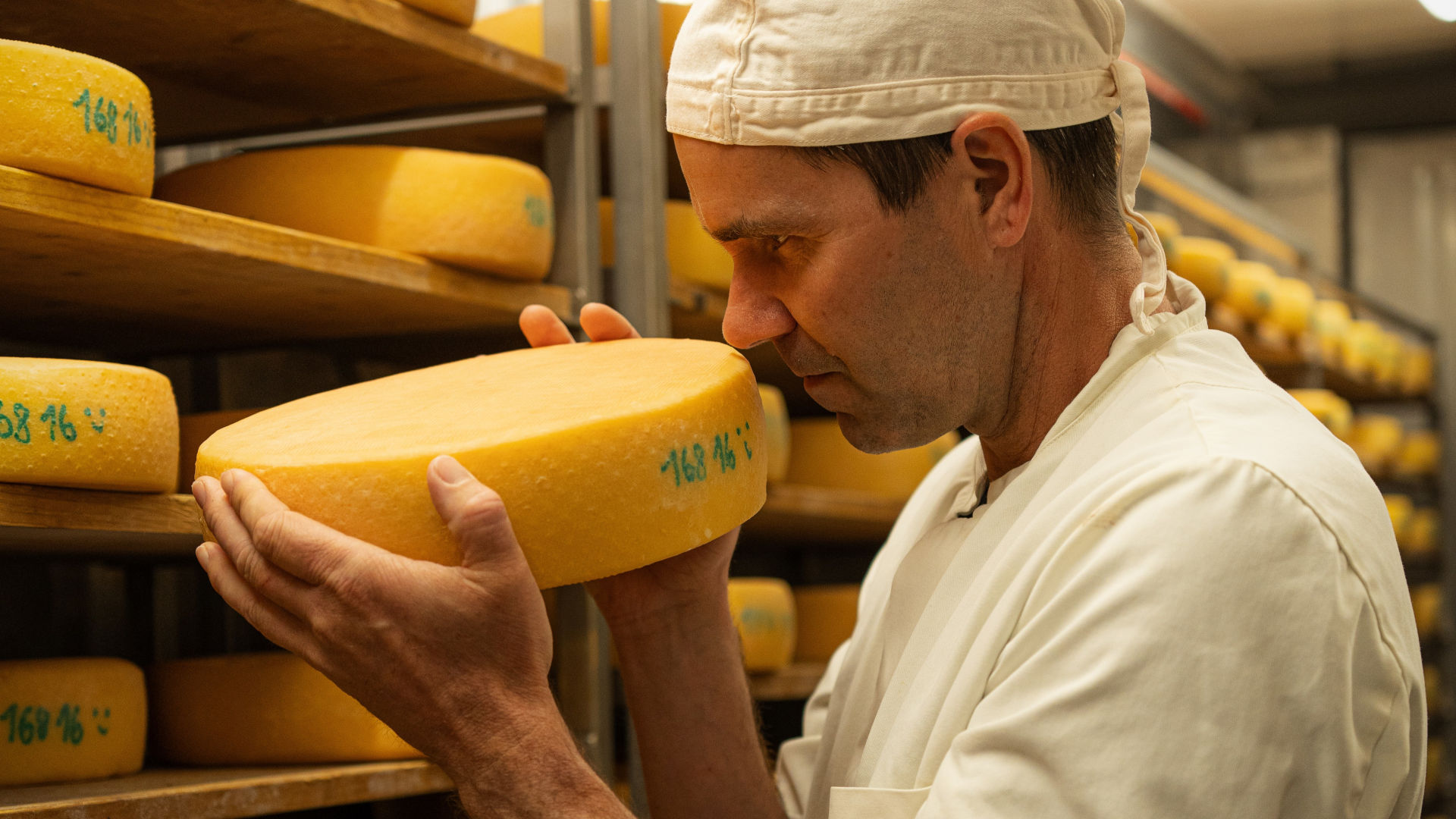 Ein Mann riecht an einem Laib Käse