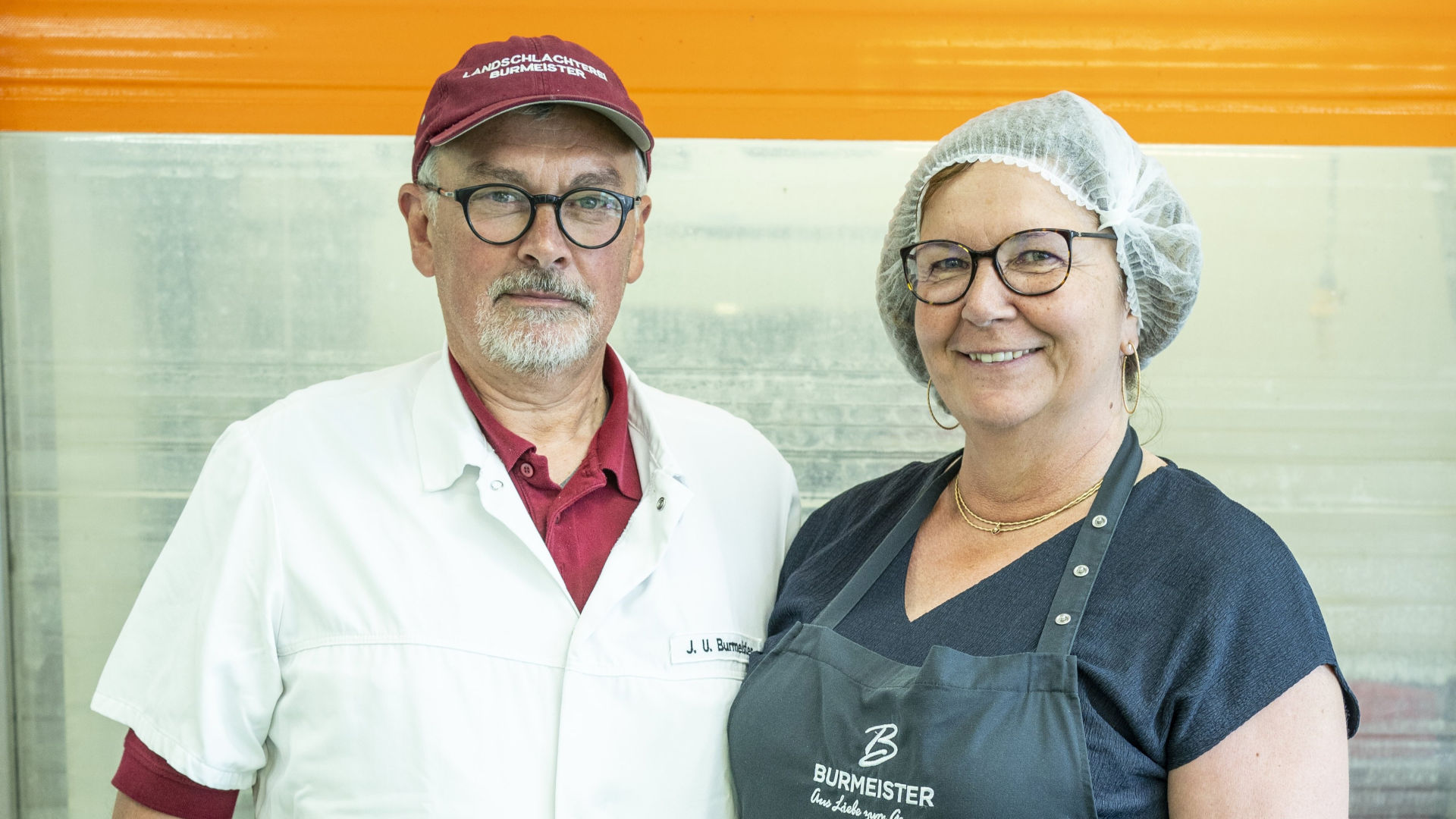 Mann und eine Frau im Portrait lächeln in die Kamera