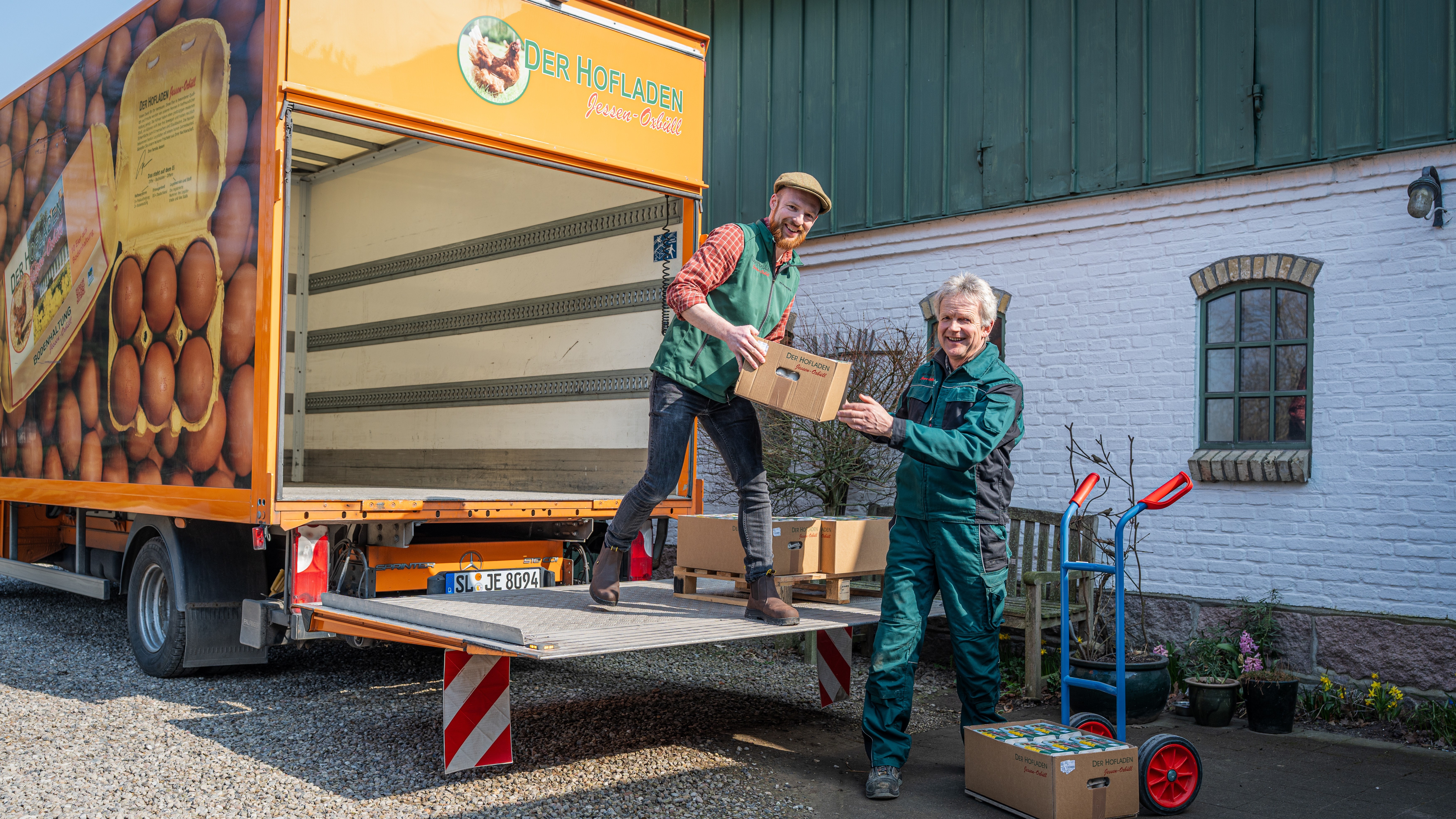 zwei Männer beladen einen LKW