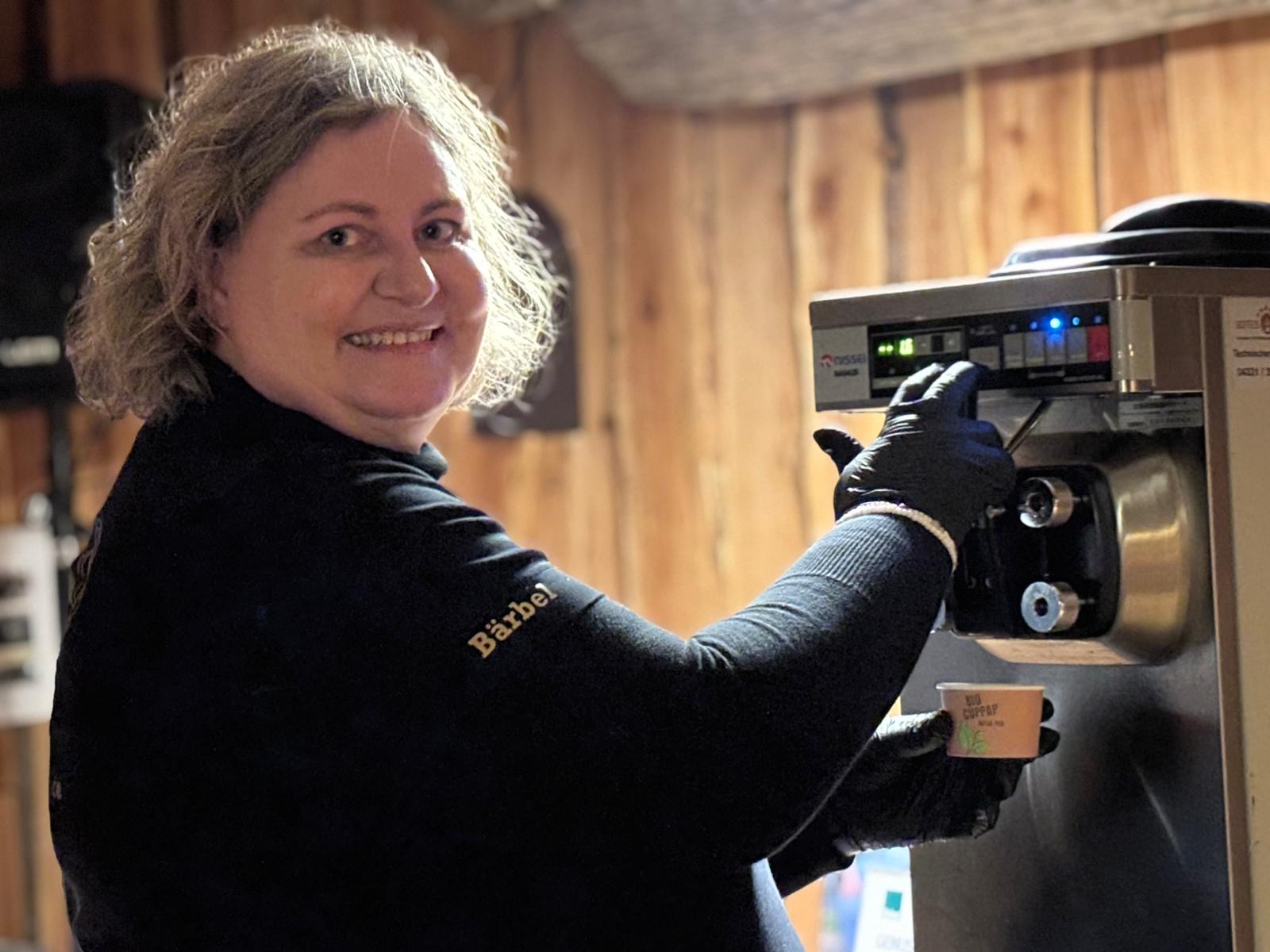 Frau steht an einer Eismaschine