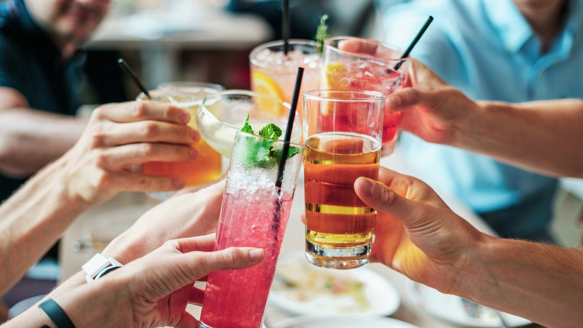 fünf Personen, die mit alkoholischen Getränken anstoßen