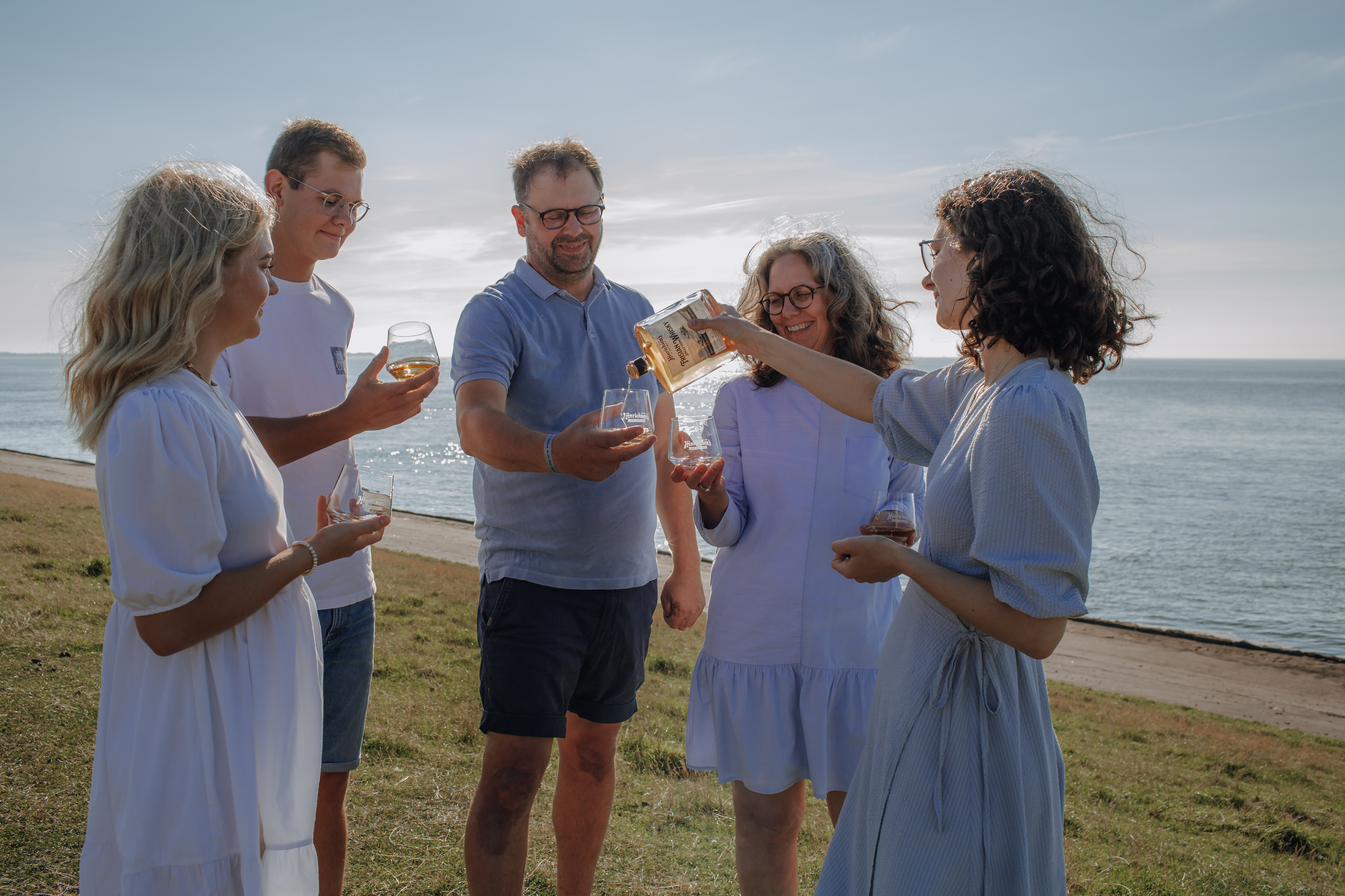 fünf Personen, die mit alkoholischen Getränken anstoßen