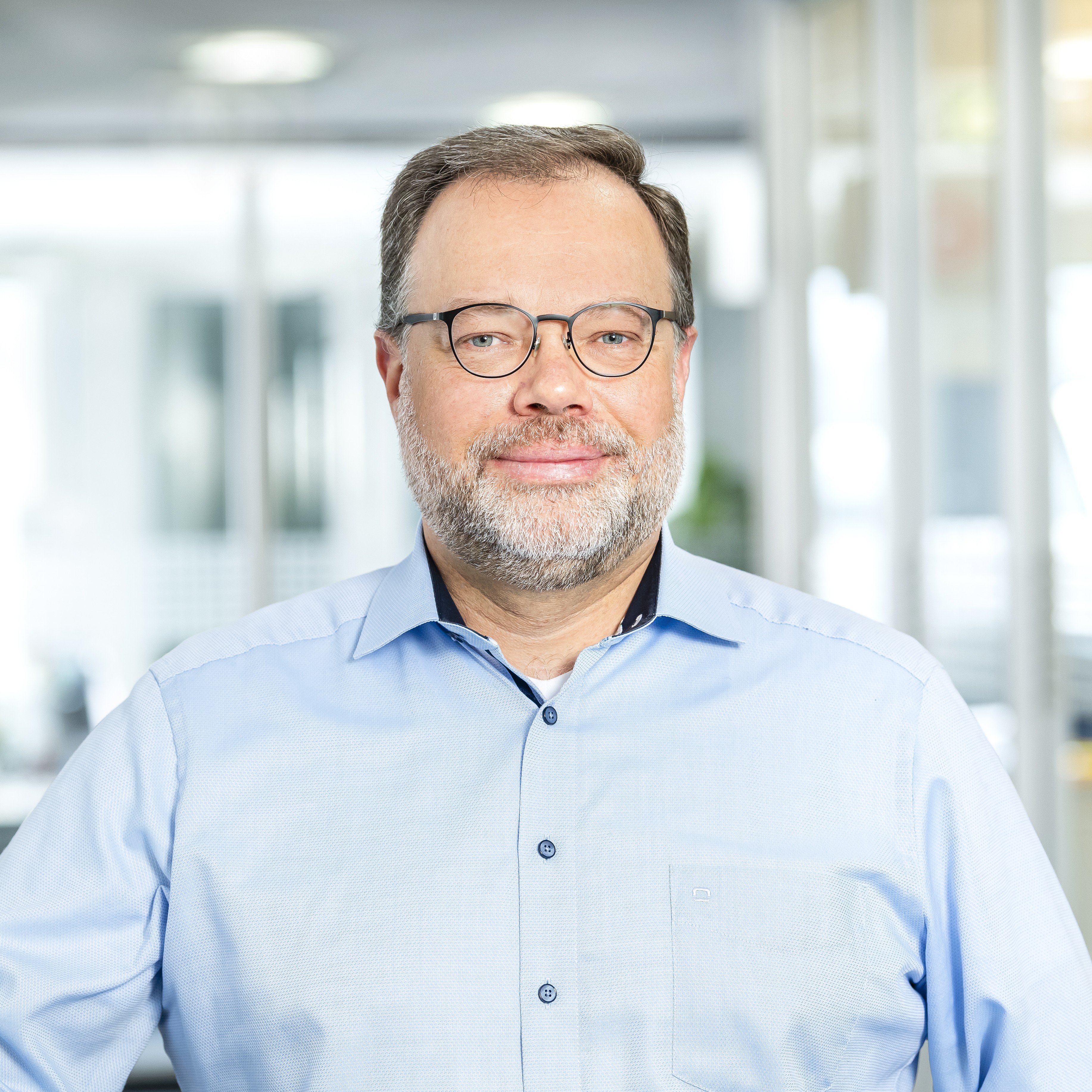 Mann mit Brille und blauem Hemd